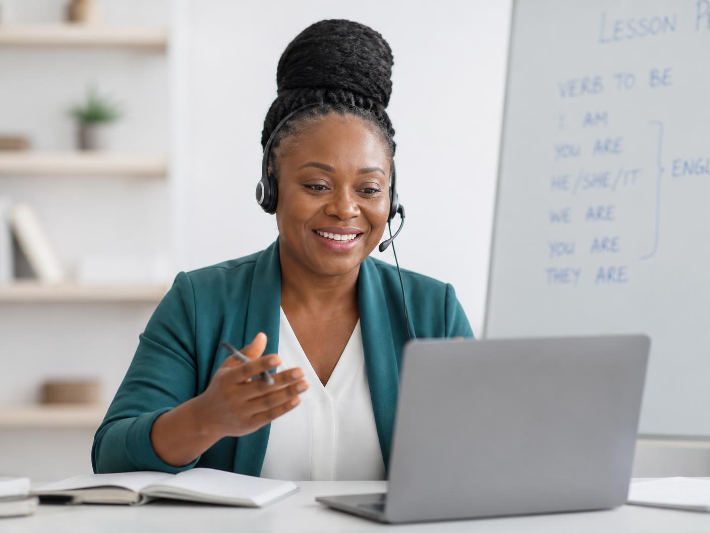 An experienced teacher delivering a live online lesson from a bright modern study